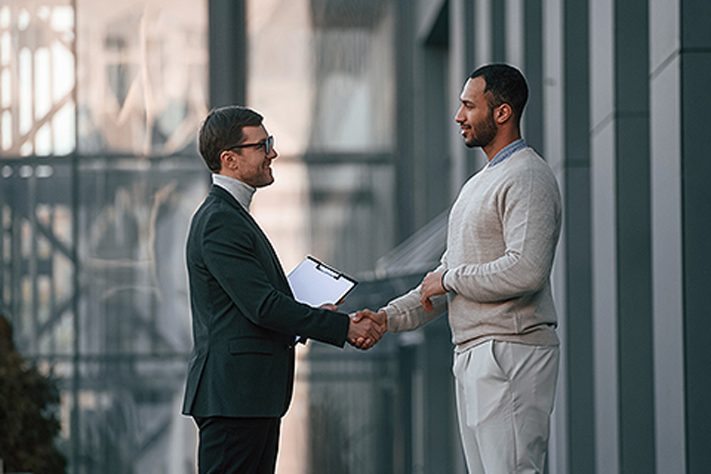 Two business men shaking hands outside